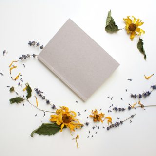 yellow flowers beside gray book