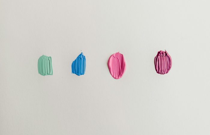 four green, blue, and pink paints